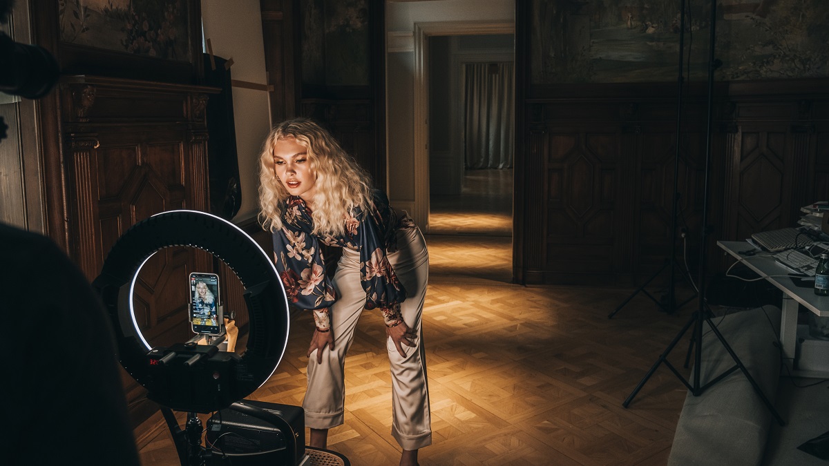 Model posing for live stream in front of a light ring